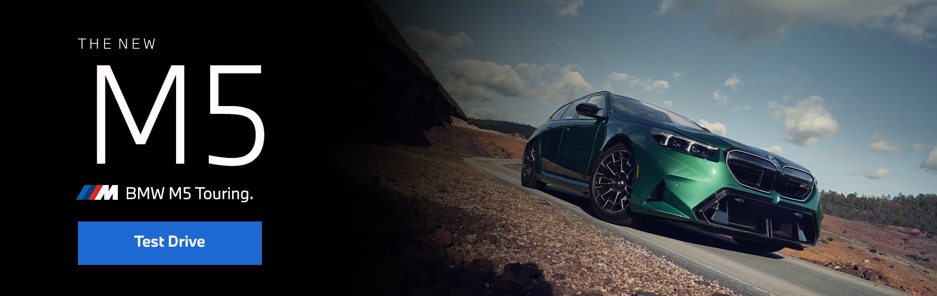 The new BMW M5 Touring in green driving down desert road | BMW of Devon in Devon PA