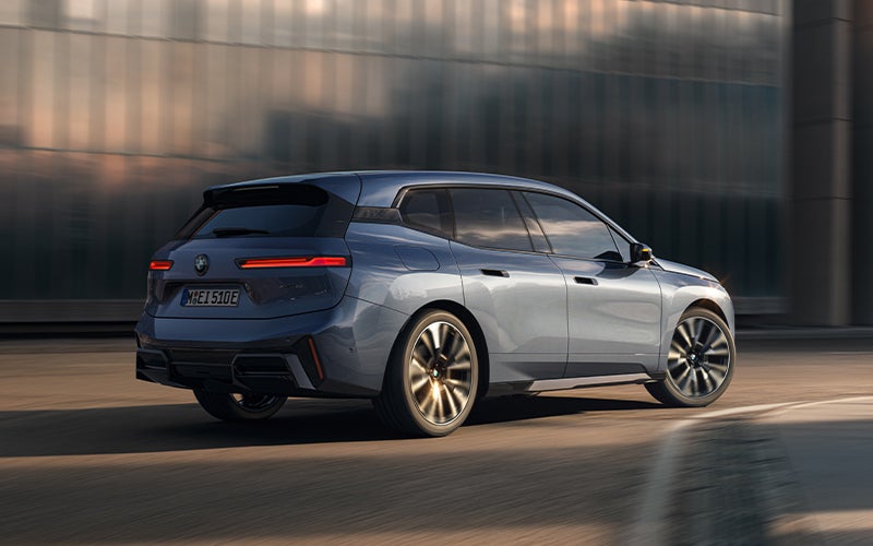 The BMW iX driving with the front wheel turned. | BMW of Devon in Devon PA