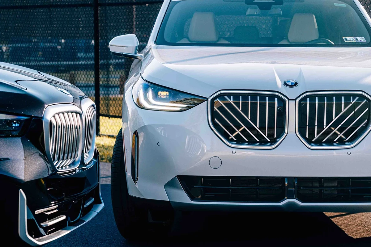 Angled Black Sapphire Metallic 2026 BMW X5 Front Grill up against a Mineral White Metallic 2026 BMW X3 Front Grill.